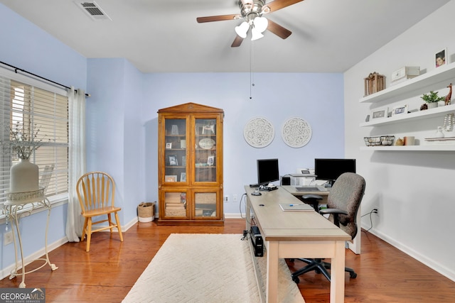 office space featuring visible vents, baseboards, wood finished floors, and ceiling fan
