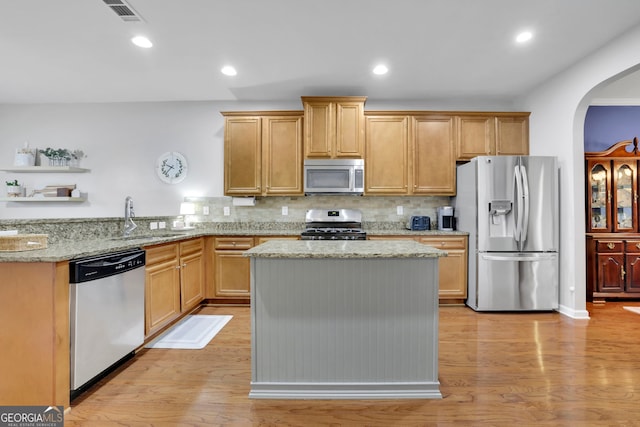 kitchen with visible vents, arched walkways, a sink, light wood-type flooring, and appliances with stainless steel finishes
