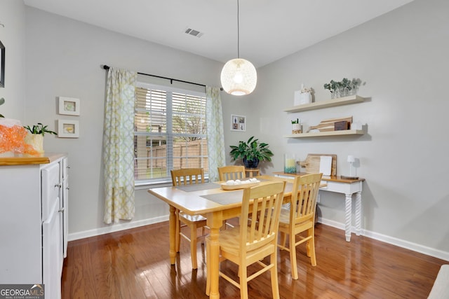 dining area with wood finished floors, baseboards, and visible vents