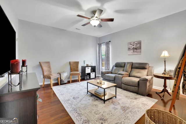 living area with dark wood-type flooring, visible vents, baseboards, and ceiling fan