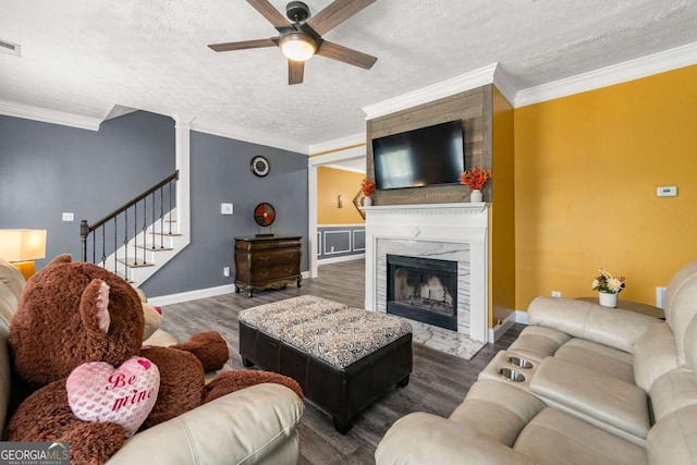 living room featuring a ceiling fan, ornamental molding, and wood finished floors