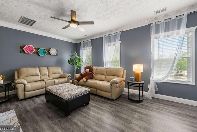 living room featuring ceiling fan, ornamental molding, visible vents, and dark wood-style flooring
