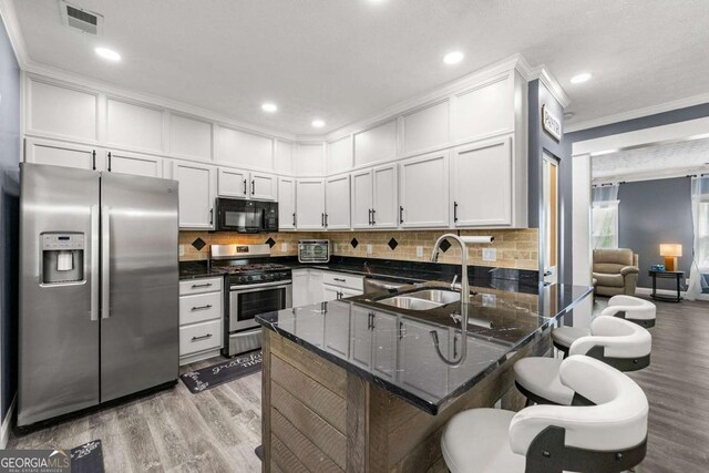 kitchen featuring tasteful backsplash, visible vents, a sink, appliances with stainless steel finishes, and a peninsula