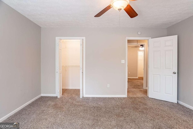 477 Victoria Rd, Woodstock, GA 30189 - unfurnished bedroom with carpet, a spacious closet, a textured ceiling, a closet, and ceiling fan