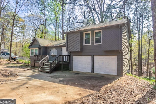 477 Victoria Rd, Woodstock, GA 30189 - tri-level home featuring a garage, concrete driveway, and a wooden deck
