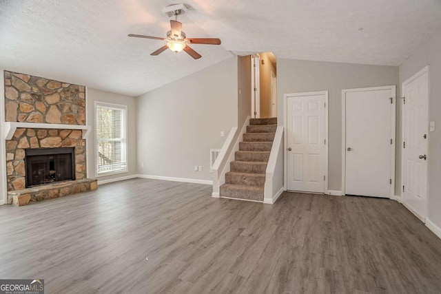 477 Victoria Rd, Woodstock, GA 30189 - unfurnished living room with lofted ceiling, ceiling fan, wood finished floors, stairway, and a fireplace