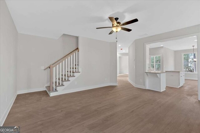 4444 Sullivan Rd, Powder Springs, GA 30127 - unfurnished living room featuring stairs, wood finished floors, baseboards, and a ceiling fan