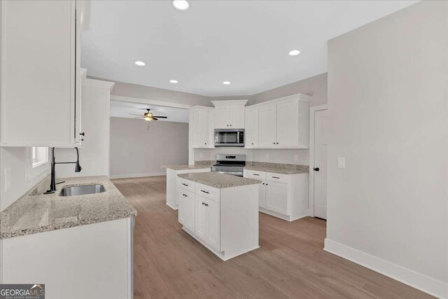 4444 Sullivan Rd, Powder Springs, GA 30127 - kitchen with a sink, a ceiling fan, white cabinetry, appliances with stainless steel finishes, and light wood-style flooring