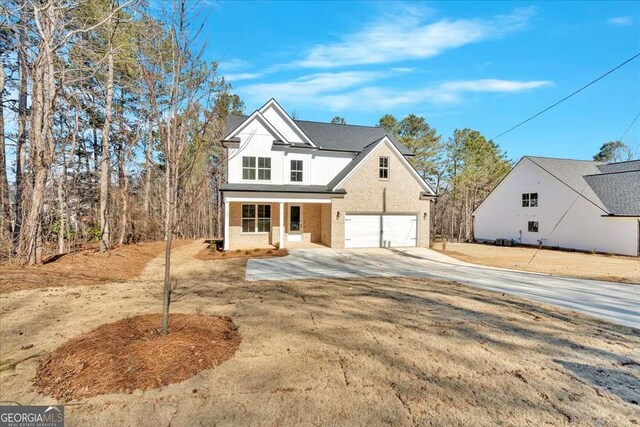 4444 Sullivan Rd, Powder Springs, GA 30127 - view of front of house featuring a porch, concrete driveway, and a garage