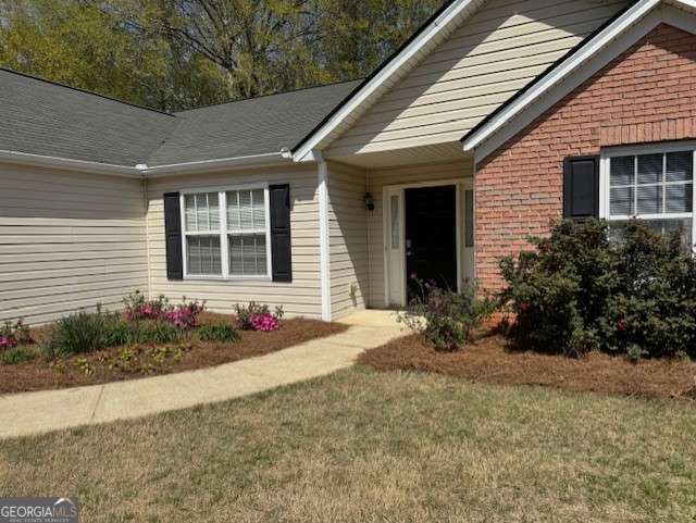 entrance to property with a lawn
