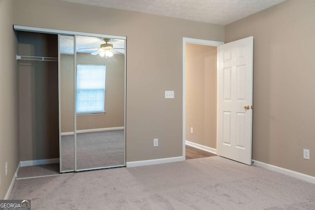 unfurnished bedroom featuring carpet, baseboards, a closet, and a textured ceiling