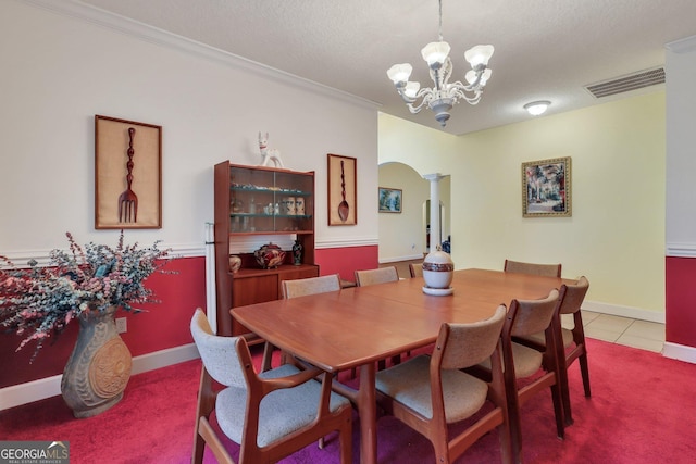 tiled dining area featuring a notable chandelier, a textured ceiling, visible vents, arched walkways, and ornate columns