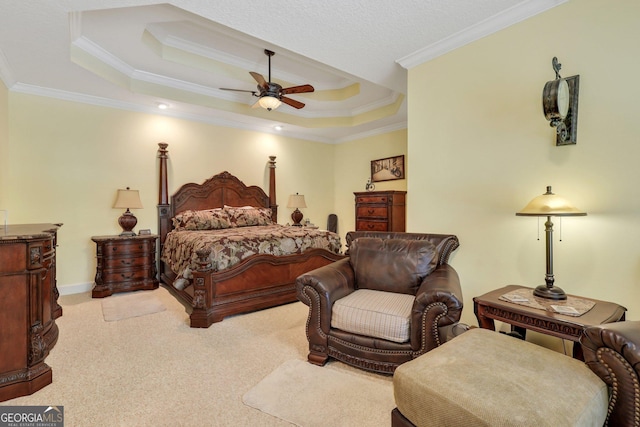 bedroom featuring a tray ceiling, crown molding, baseboards, ceiling fan, and light carpet