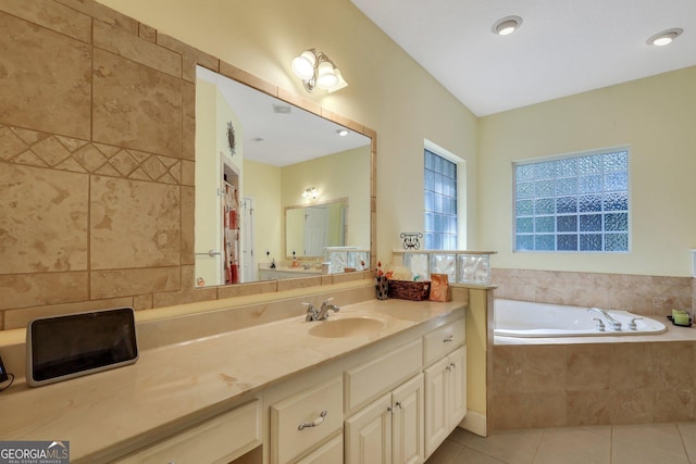 bathroom featuring tile patterned flooring, vanity, and a bath