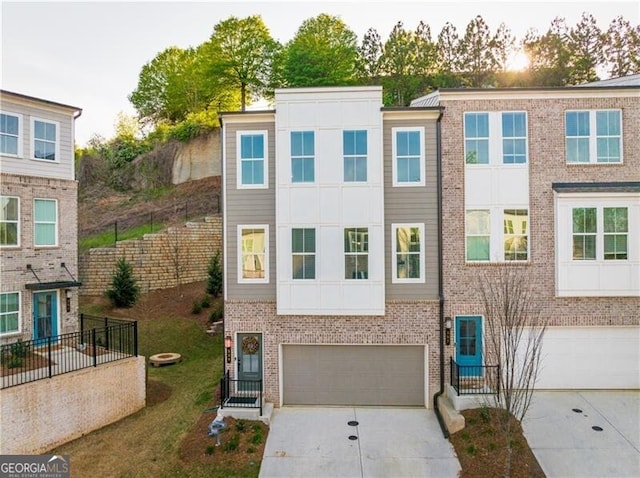 multi unit property with driveway, an attached garage, and brick siding