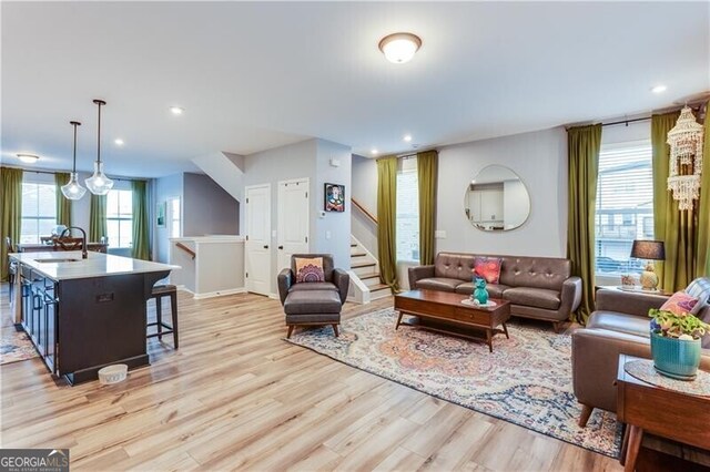 living area featuring recessed lighting, stairway, and light wood finished floors