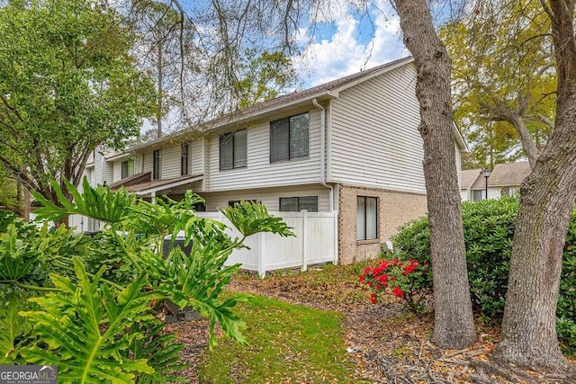 809 Mallery St Unit A, Saint Simons, GA 31522 - view of side of home featuring fence and brick siding