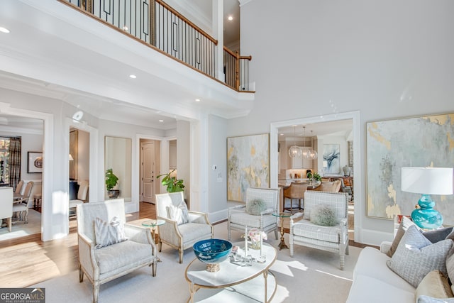 living area featuring baseboards, crown molding, wood finished floors, and recessed lighting