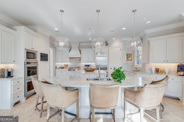 kitchen featuring a notable chandelier, a spacious island, a sink, built in appliances, and custom range hood
