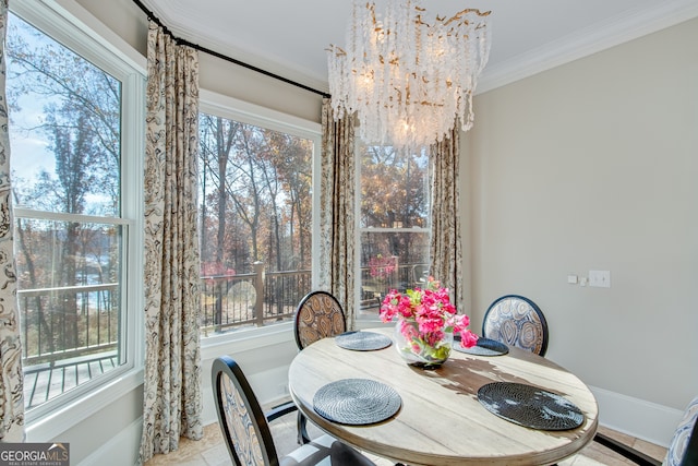 dining space featuring baseboards, ornamental molding, and a notable chandelier