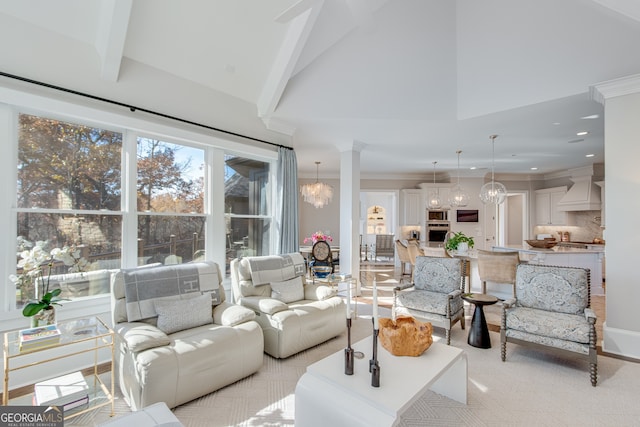 living area featuring high vaulted ceiling, crown molding, an inviting chandelier, and decorative columns