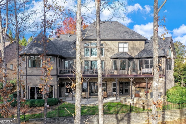 rear view of property featuring fence private yard, a patio area, and roof with shingles
