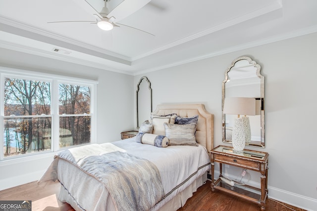 bedroom featuring visible vents, wood finished floors, and a raised ceiling