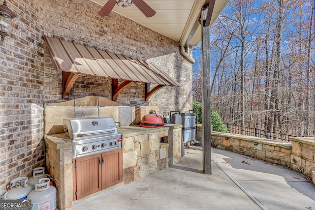 view of patio with ceiling fan, an outdoor kitchen, and area for grilling