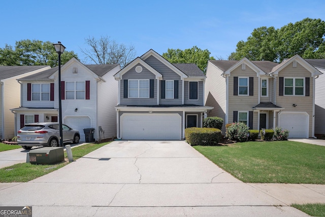 view of front of house featuring an attached garage, concrete driveway, and a front lawn