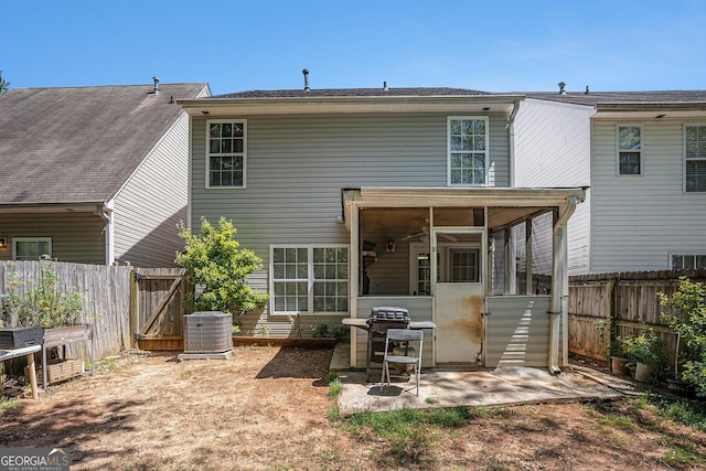rear view of property with a sunroom, a fenced backyard, a gate, central air condition unit, and a patio