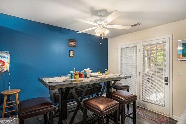 dining area with a ceiling fan, baseboards, visible vents, and wood finished floors