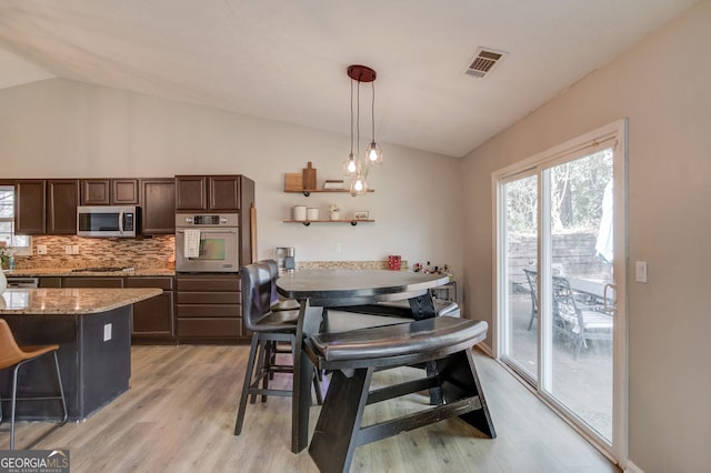 dining area featuring lofted ceiling, visible vents, and light wood finished floors