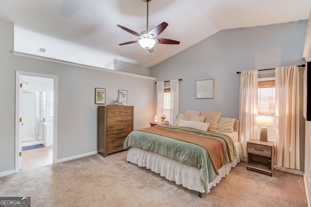 bedroom featuring vaulted ceiling, connected bathroom, light colored carpet, baseboards, and visible vents
