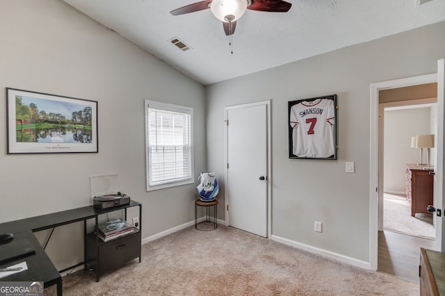 interior space featuring lofted ceiling, visible vents, a ceiling fan, carpet floors, and baseboards