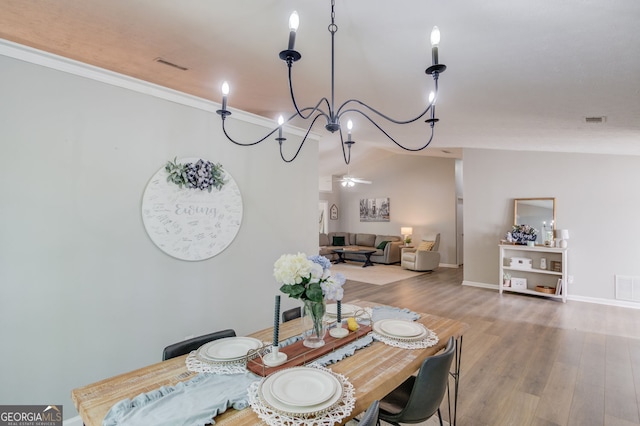 dining area with baseboards, wood finished floors, visible vents, and crown molding