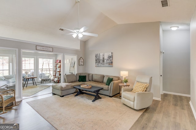 living area with baseboards, visible vents, lofted ceiling, wood finished floors, and ceiling fan