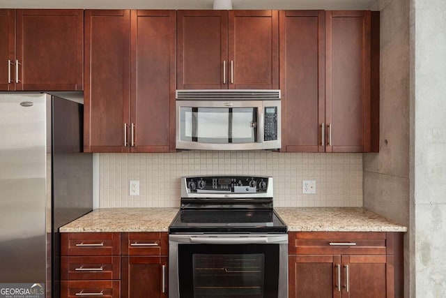 855 Peachtree St NE Unit 2403, Atlanta, GA 30308 - kitchen featuring appliances with stainless steel finishes, reddish brown cabinets, tasteful backsplash, and light stone counters