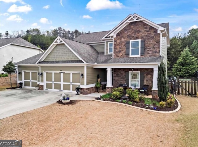 108 Summer Breeze Ln, Canton, GA 30114 - craftsman-style house with stone siding, an attached garage, fence, driveway, and covered porch
