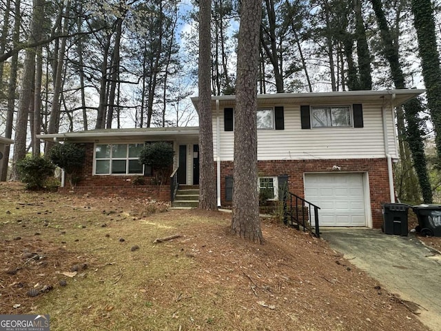 3025 Mckenzie Rd, Atlanta, GA 30344 - tri-level home featuring a garage, brick siding, and concrete driveway