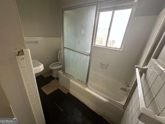 3025 Mckenzie Rd, Atlanta, GA 30344 - bathroom with tile walls, shower / bath combination with glass door, and a wainscoted wall