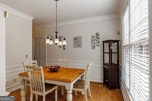 2032 Stonewick Ct, Lawrenceville, GA 30043 - dining room with ornamental molding, a chandelier, a decorative wall, light wood-type flooring, and wainscoting