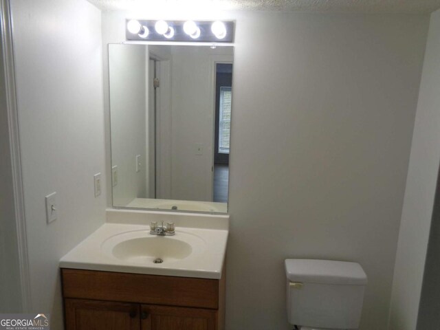 half bath featuring toilet and vanity