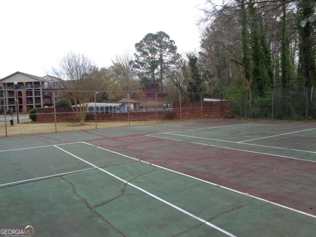 view of tennis court featuring fence and community basketball court