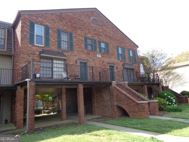 view of front of property featuring stairs, a patio, and brick siding