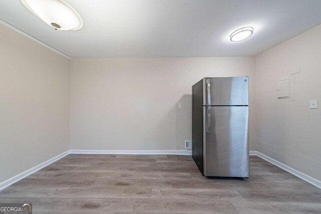 kitchen with freestanding refrigerator, visible vents, baseboards, and wood finished floors