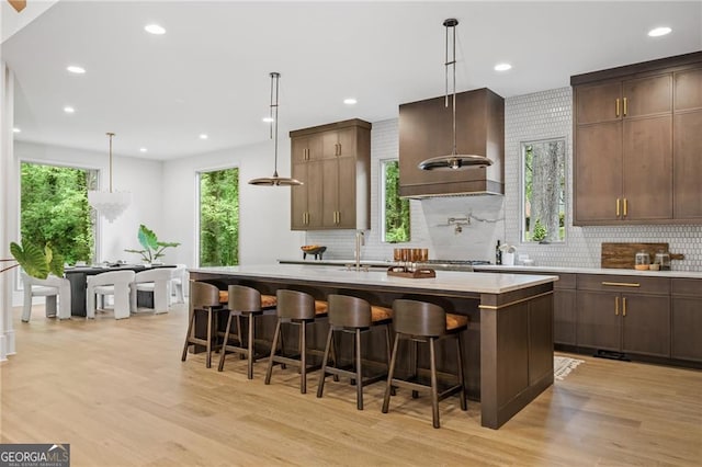 402 Chattahoochee St, Roswell, GA 30075 - kitchen featuring light wood-style flooring, light countertops, a kitchen island with sink, tasteful backsplash, and recessed lighting