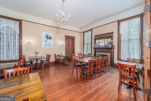 622 Main St, Blackshear, GA 31516 - dining room with a fireplace, hardwood / wood-style flooring, baseboards, and a chandelier
