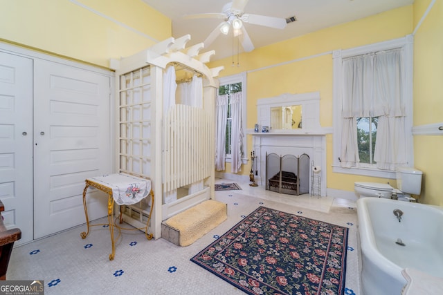 622 Main St, Blackshear, GA 31516 - bathroom featuring visible vents, a bath, a fireplace, and ceiling fan