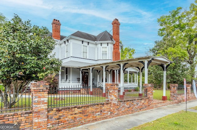 622 Main St, Blackshear, GA 31516 - victorian home with a porch, a fenced front yard, and a chimney