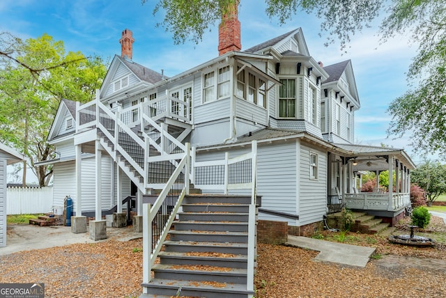 622 Main St, Blackshear, GA 31516 - view of side of property with stairs, a chimney, and covered porch